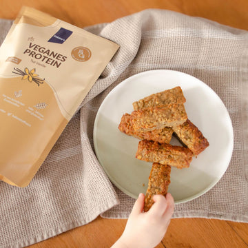 Vegane Proteinküchlein auf einem Teller mit Kinderhand