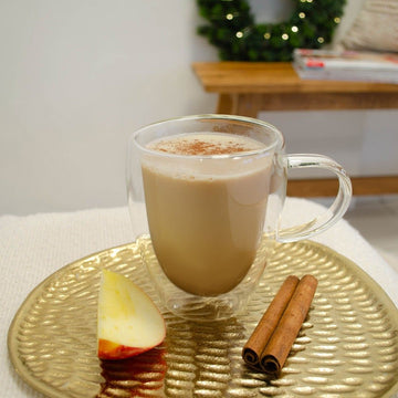 Veganer Bratapfel-Haferdrink in einer Tasse mit Apfel und Zimt
