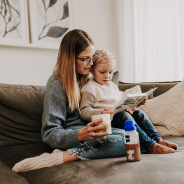 Mutter mit Kind sitzen gemütlich auf dem Sofa