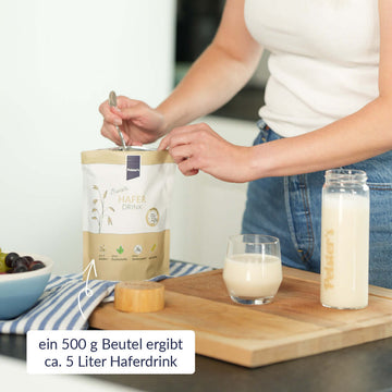 Frau, die Pulver aus dem Barista Haferdrink Beutel nimmt 