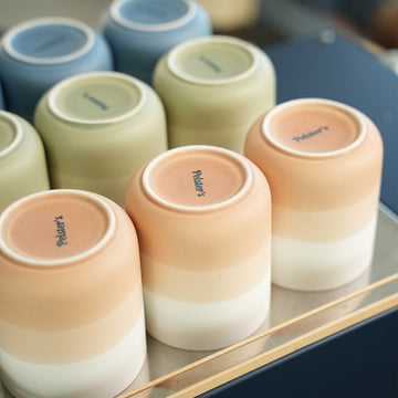 Porzellan Becher in verschiedenen Farben mit Pelsters Logo