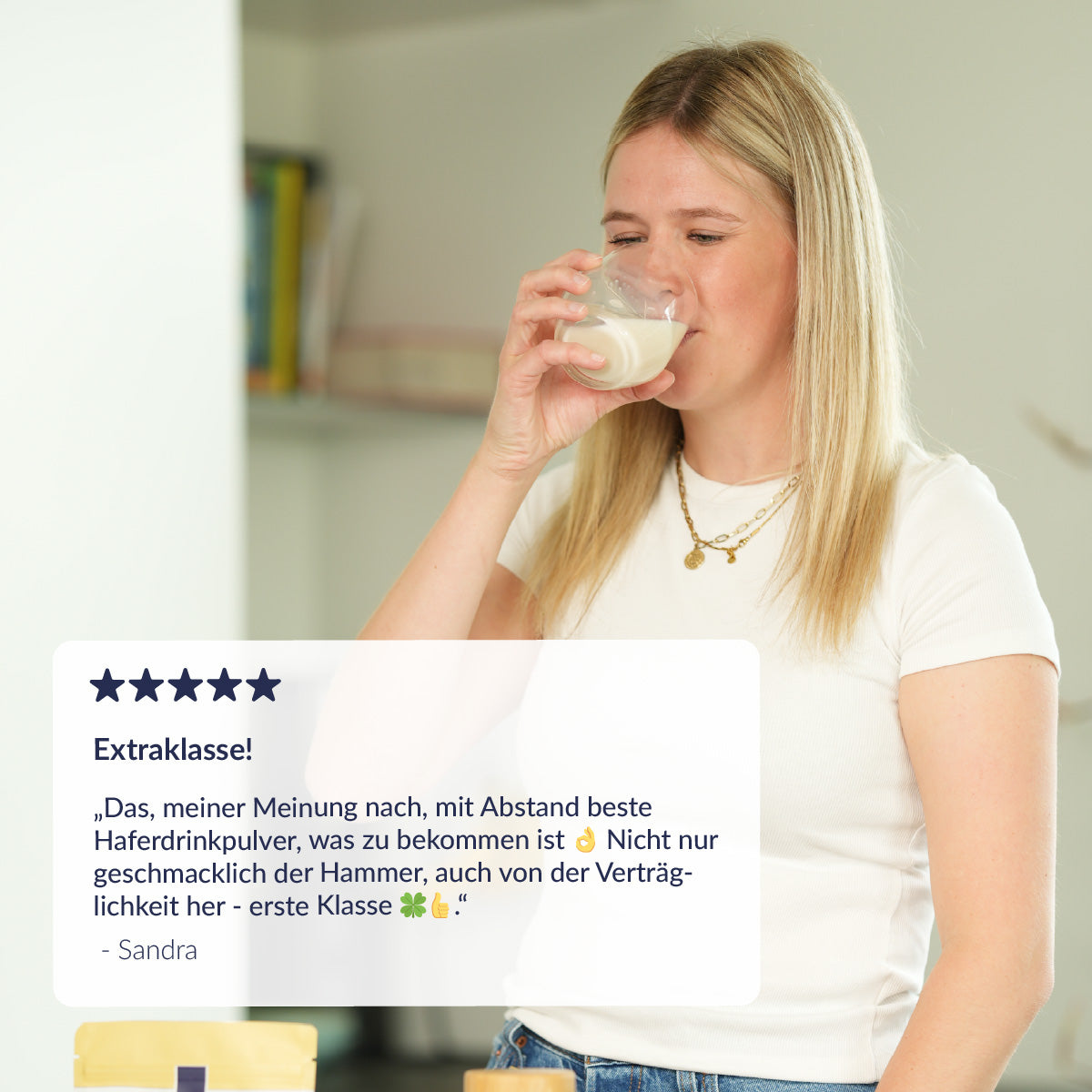 Frau die aus einem Glas Haferdrink trinkt und ein Kommentar 