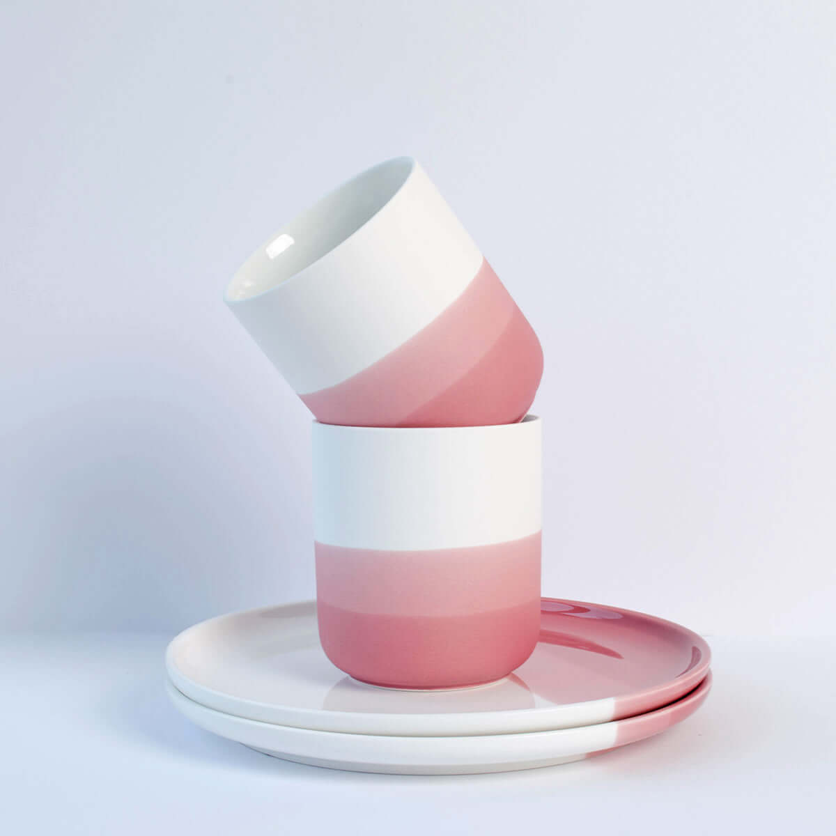 Kleines Ombré Frühstücksset aus Porzellan mit pinken Tassen und Tellern im modernen Design.